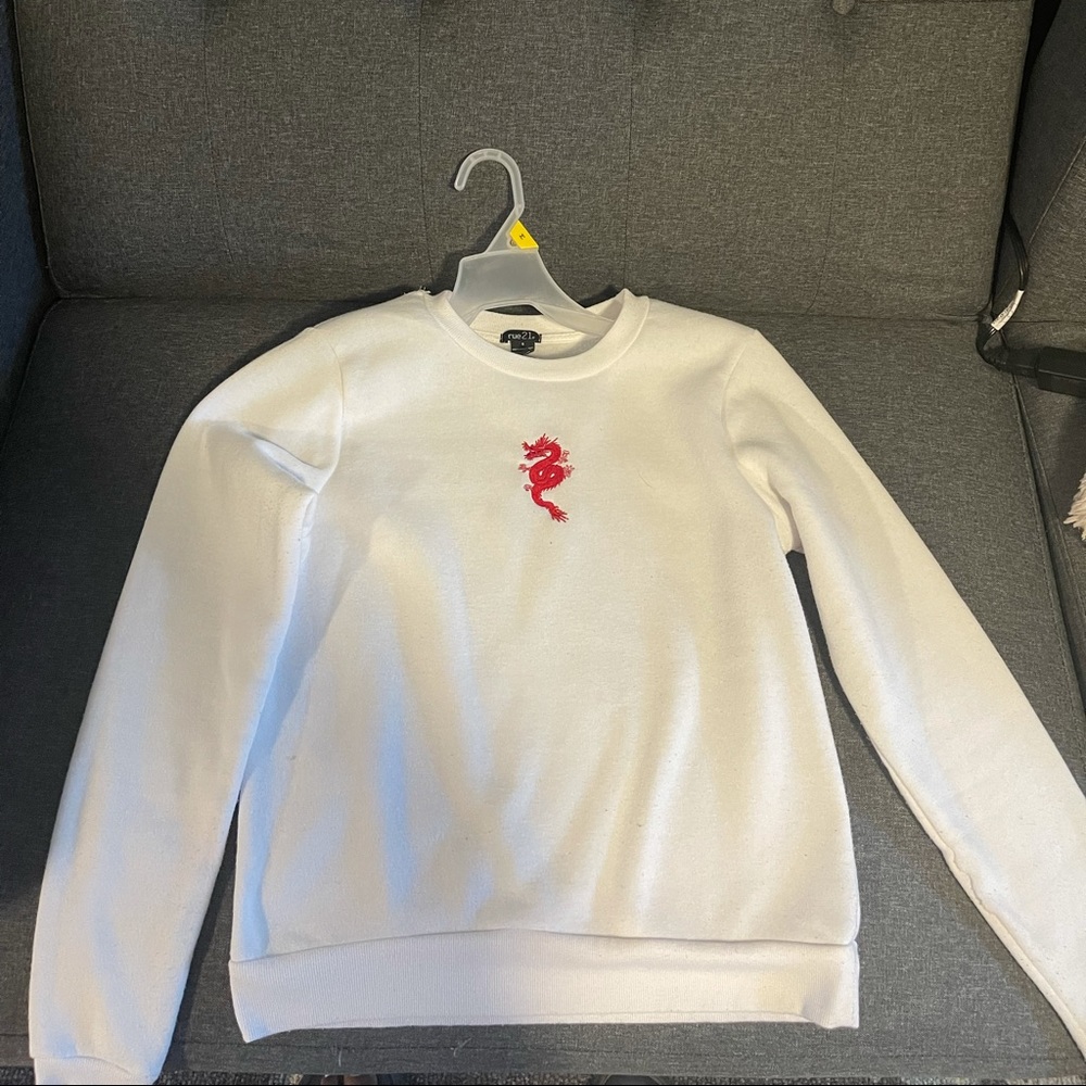 White sweatshirt with red dragon on the front.